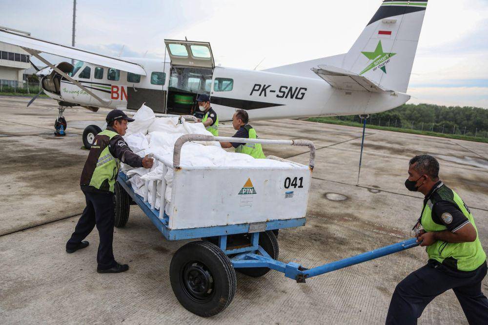Petugas menyiapkan garam sebelum dimasukkan ke dalam pesawat Cessna 208B Grand Caravan EX untuk persemaian garam dengan Teknologi Modifikasi Cuaca (TMC) di Bandara Internasional Ahmad Yani, Semarang, Jawa Tengah, Senin (18/3/2024). BNPB bekerja sama dengan BMKG melakukan operasi TMC selama tiga hari sebagai upaya meminimalisir berkumpulnya awan yang berpotensi menimbulkan intensitas hujan tinggi terjadi di sejumlah wilayah Jawa Tengah yang rawan bencana hidrometeorologi. (ANTARA/Makna Zaezar)