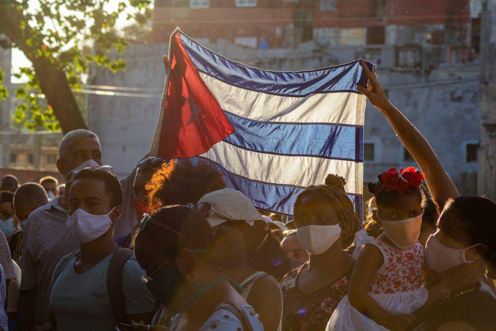 ilustrasi warga memegang bendera Kuba (unsplash.com/Ricardo IV Tamayo)