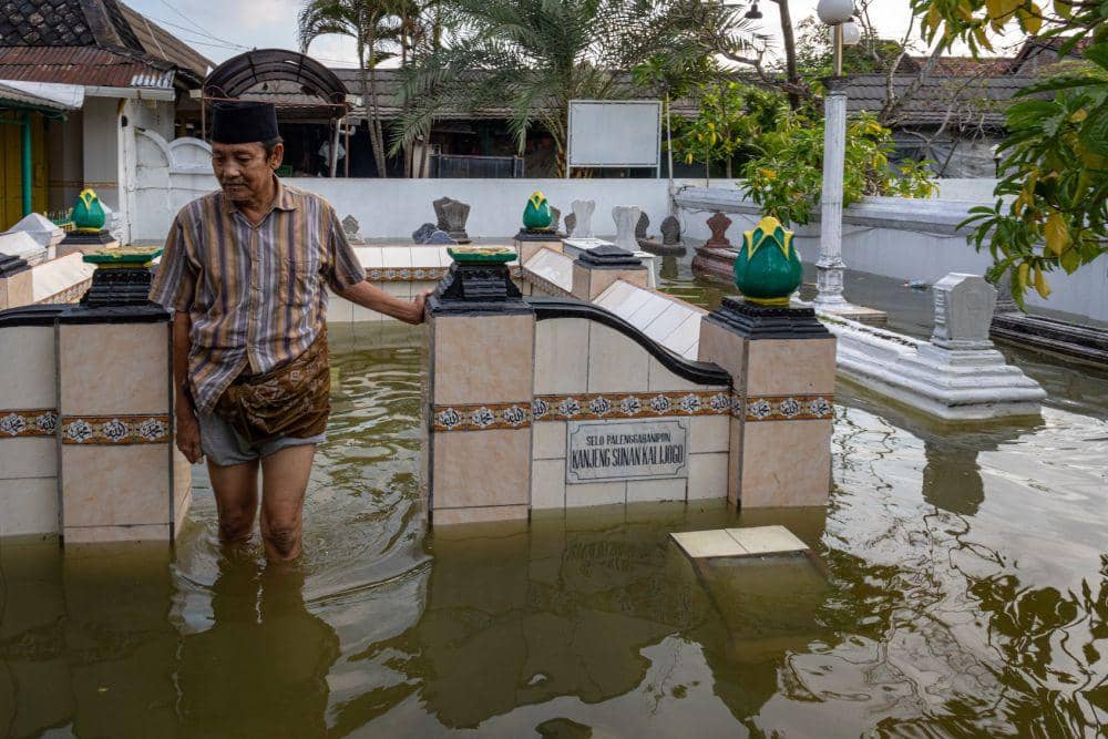 Seorang pengurus makam menunjukkan situs Selo Palenggahanipun Kanjeng Sunan Kalijaga yang terndam banjir di kawasan Cagar Budaya Situs Kompleks Makam Sunan Kalijaga di Demak, Jawa Tengah, Selasa, (19/3/2024). Banjir yang melanda Kabupaten Demak selain merendam ribuan rumah warga dan telah masuk ke pusat kota, juga merendam kawasan cagar budaya tersebut dengan ketinggian air 20-40 cm dan menurut pengurus makam belum pernah terjadi pada banjir sebelumnya. (ANTARA/Aji Styawan)