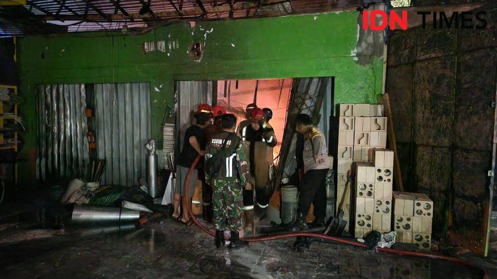 Petugas DPKP Kota Depok dan aparat keamanan setempat memadamkan api yang membakar toko bangunan di Bedahan, Sawangan, Depok. (IDNTimes/Dicky)
