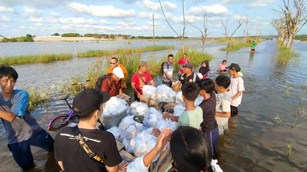 Pengurus Majelis Agama Buddha Theravada Indonesia (Magabudhi) Jawa Tengah dan lintas ikan Semarang terlihat membawa logistik yang dinaikan rakit kayu ke Desa Loireng Sayung. (IDN Times/Dok Pelita Semarang)