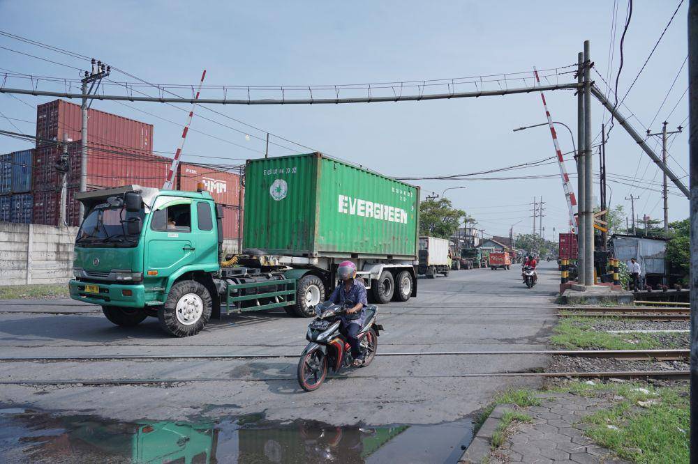 Ruas rel kereta api saat dilintasi truk trailer dan motor dengan kondisi ada sedikit genangan air. (IDN Times/Dok Humas KAI Daop 4 Semarang)