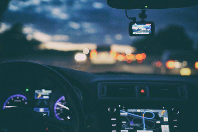 ilustrasi pengendara sedang menyetir mobil di sore menuju malam hari (unsplash.com/Mark Cruz)