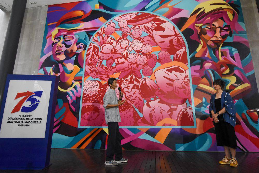 Kolaborasi mural berjudul Together oleh seniman Indonesia Tutu (kiri) dan Australia George Rose (kanan)