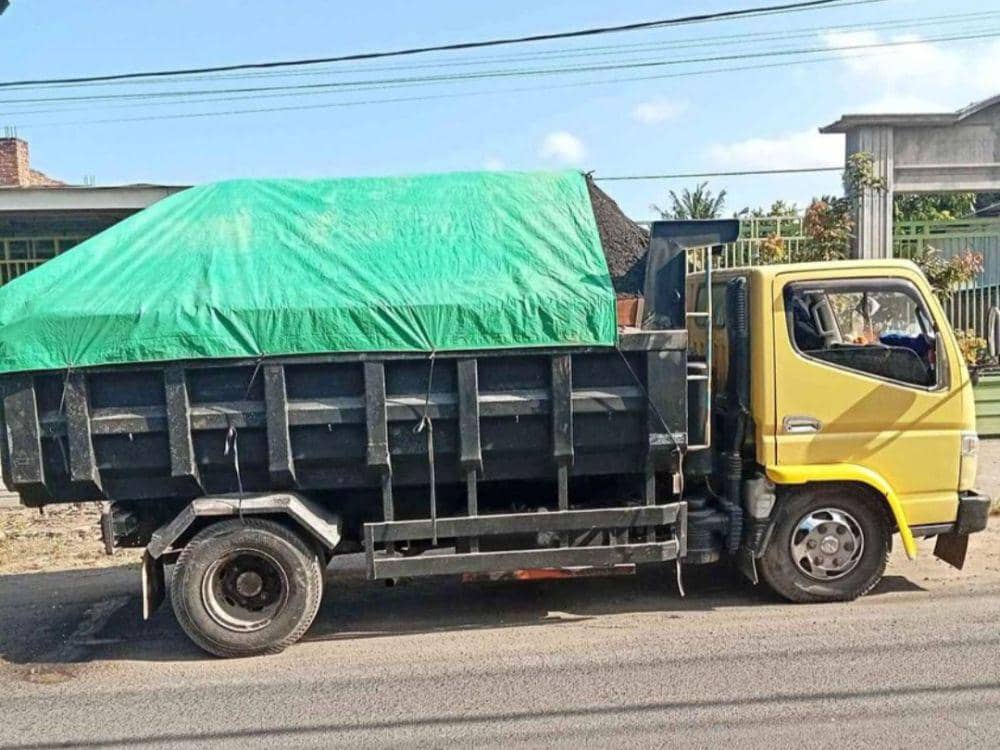 Ilustrasi dump truck pengangkut pasir. (IDN Times/Ruhaili)