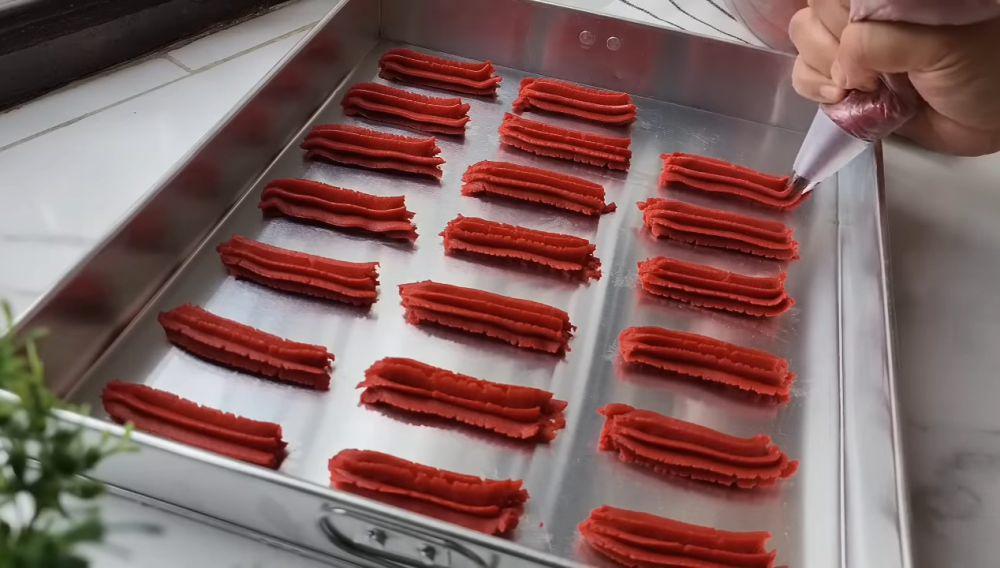 ilustrasi spuit adonan red velvet cookies di atas loyang (YouTube.com/atha naufal)