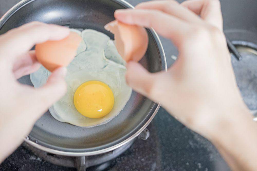 Ilustrasi memecahkan telur ayam di atas teflon (unsplash.com/margabagus)
