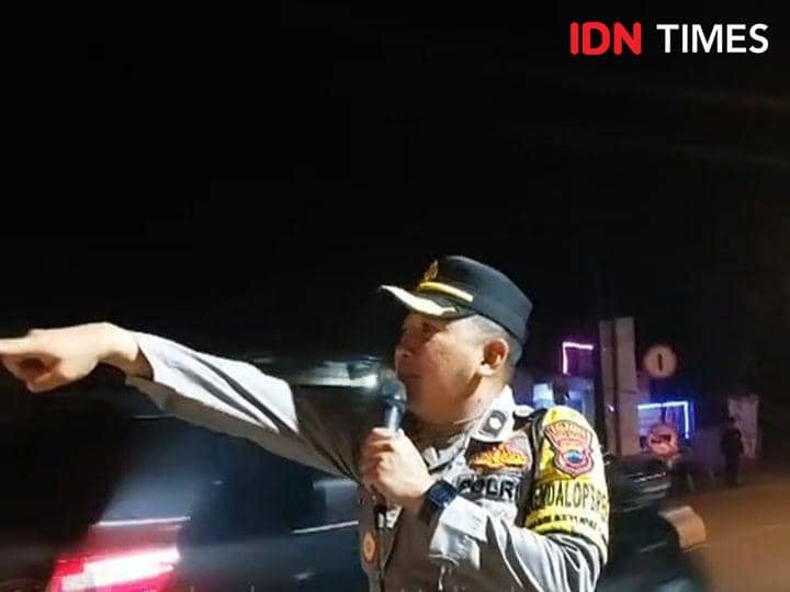 Kabagops Polresta Banyumas Kompol Amjat nampak berupaya keras menghimbau melaui pengeras suara agar pemudik balik tertib, Minggu (14/4/2024).(IDN Times/Cokie Sutrisno)
