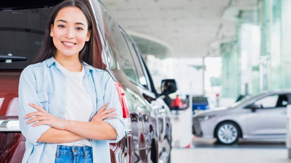 Seorang wanita berdiri dibelakang mobil (freepik.com/freepik)