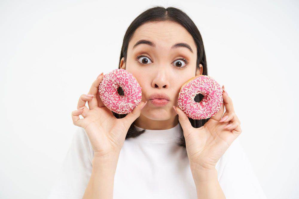 ilustrasi perempuan memegang donat (freepik.com/benzoix)
