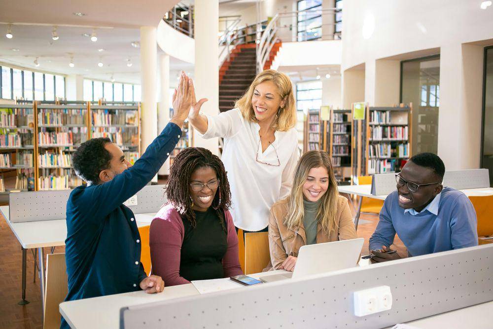 https://www.pexels.com/photo/cheerful-multiethnic-students-having-high-five-with-teacher-5940841/