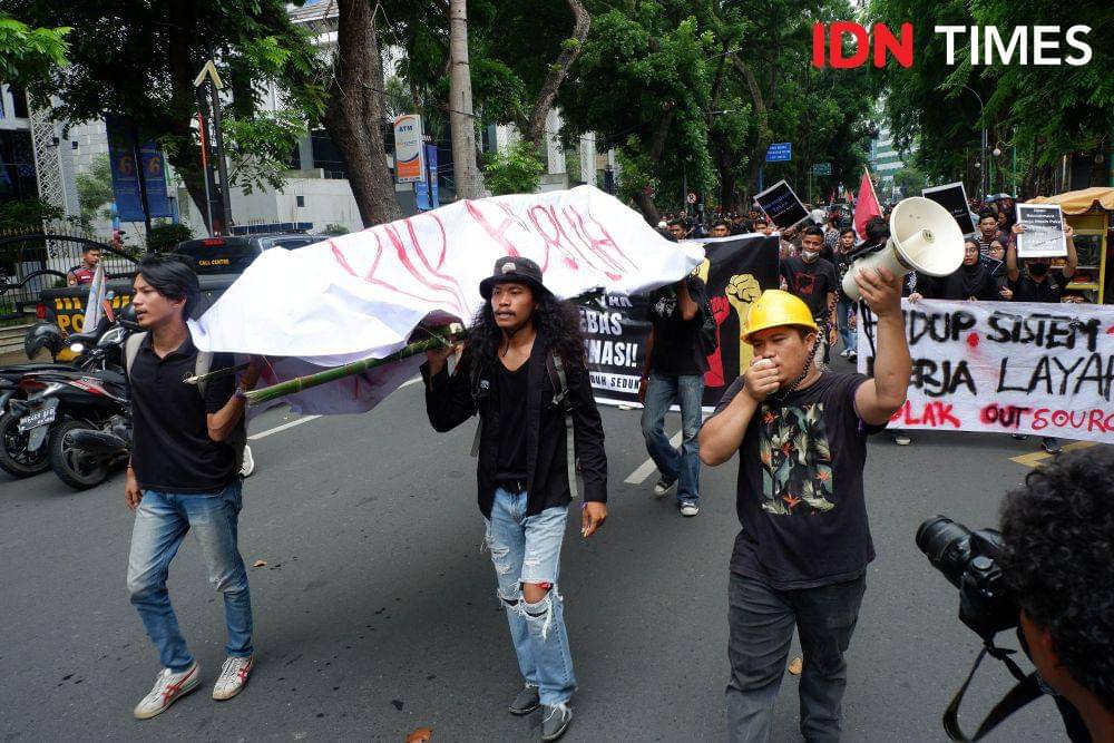 Massa AKBAR Sumut mengarak keranda dalam aksi unjuk rasa Hari Buruh Internasional, Rabu (1/5/2024). (IDN Times/Prayugo Utomo)