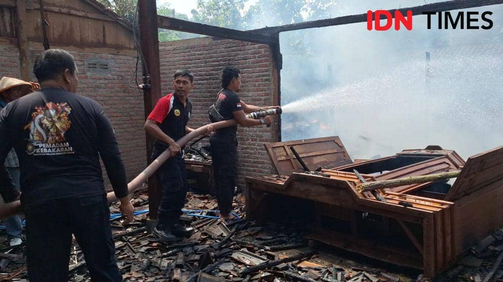 Petugas dari Damkar Ngawi menyemprotkan air ke-rumah yang terbakar/ IDN Times/ Riyanto