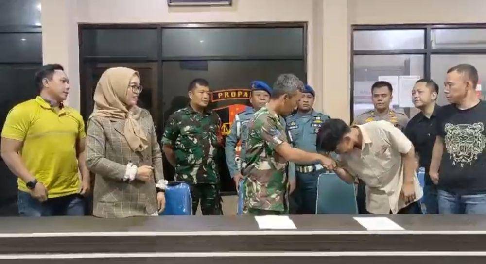 Pengendara katering, Afif, mencium tangan Kopka Choirul Anam usai sempat cekcok di daerah Cileungsi. (Tangkapan layar dokumentasi TNI AL)