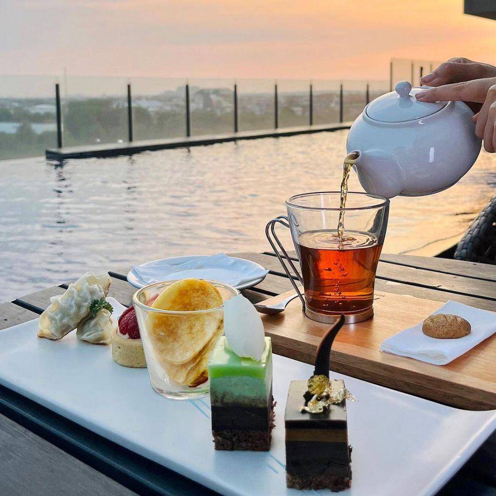 Tea time dari tepi kolam renang hotel Movenpick Surabaya. Instagram/movenpicksurabayacity