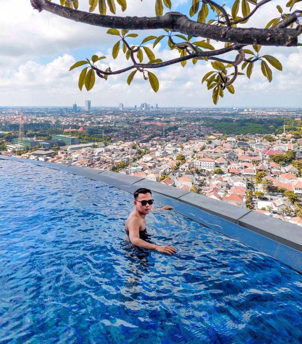 Pengunjung yang tengah menikmati kolam renang hotel Ciputra World Surabaya. Instagram/hotelciputraworldsby