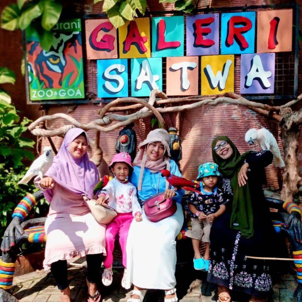 Pengunjung yang tengah berfoto bersama burung di Maharani Zoo Lamongan. Instagram/maharanizoo