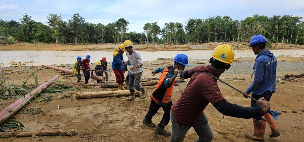 Akibat akses jembatan terputus, petugas PLN tengah berjibaku memobilisasi tiang melewati sungai ke Dusun Ajjilikeng, Kabupaten Wajo, Kamis (9/5/2024). Dok. PLN UID Sulselrabar