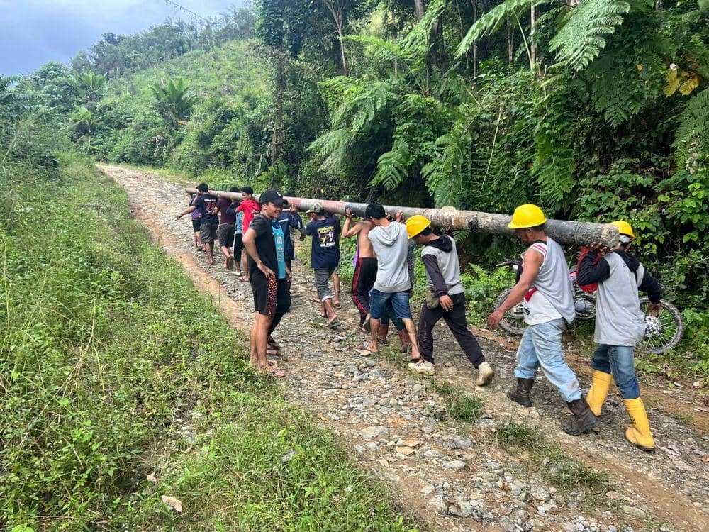Masyarakat Dusun Matajang, Kabupaten Sidrap turut bergotong royong membantu PLN dalam memobilisasi tiang untuk mempercepat pemulihan pasokan listrik yang terdampak bencana, Kamis (9/5/2024). Dok. PLN UID Sulselrabar