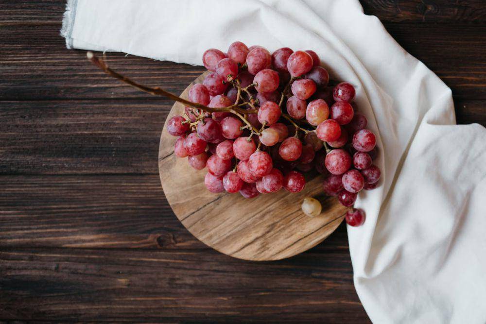 ilustrasi buah anggur di atas papan kayu (pexels.com/Polina Kovaleva)