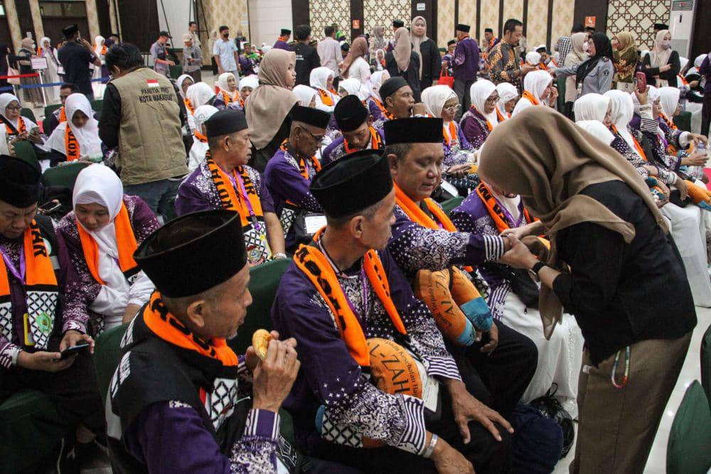 Petugas memasangkan gelang kepada Jemaah Calon Haji (JCH) kelompok terbang (kloter) pertama embarkasi Makassar di Asrama Haji Sudiang, Makassar, Sulawesi Selatan, Sabtu (11/5/2024). ANTARA FOTO/Arnas Padda/aww.