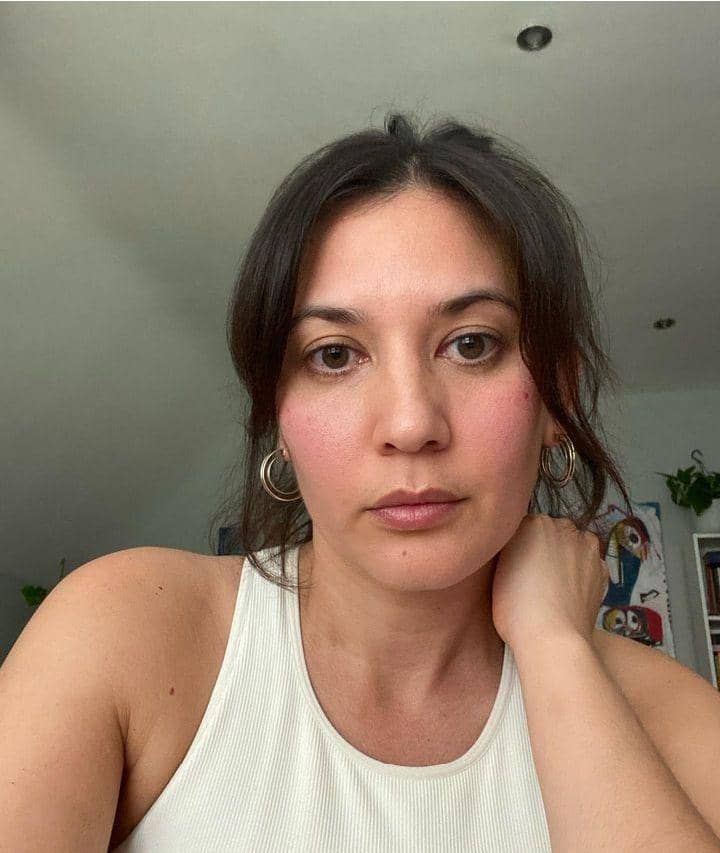 Hannah Al Rashid tampil dalam potret close-up dengan riasan natural dan rambut terurai, menatap ke arah kamera.