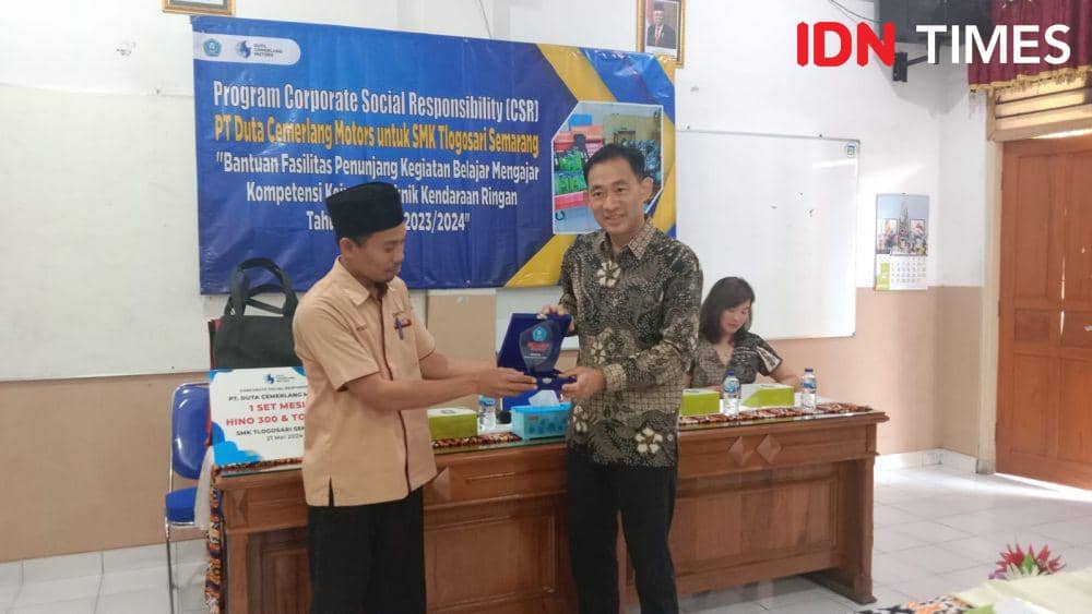Kepsek SMK Tlogosari Markibi serahkan cinderamata kepada Christian Hemasurya, Direktur Utama PT Duta Cemerlang Motors. (IDN Times/Fariz Fardianto)