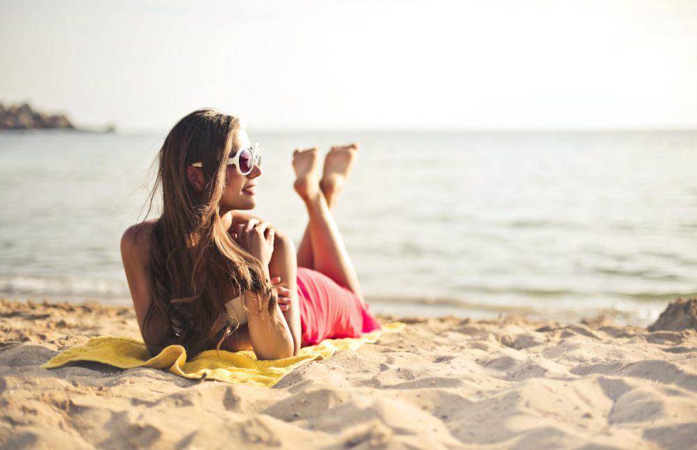 ilustrasi wanita memakai kacamata hitam di pantai (pexels.com/Andrea Piacquadio)