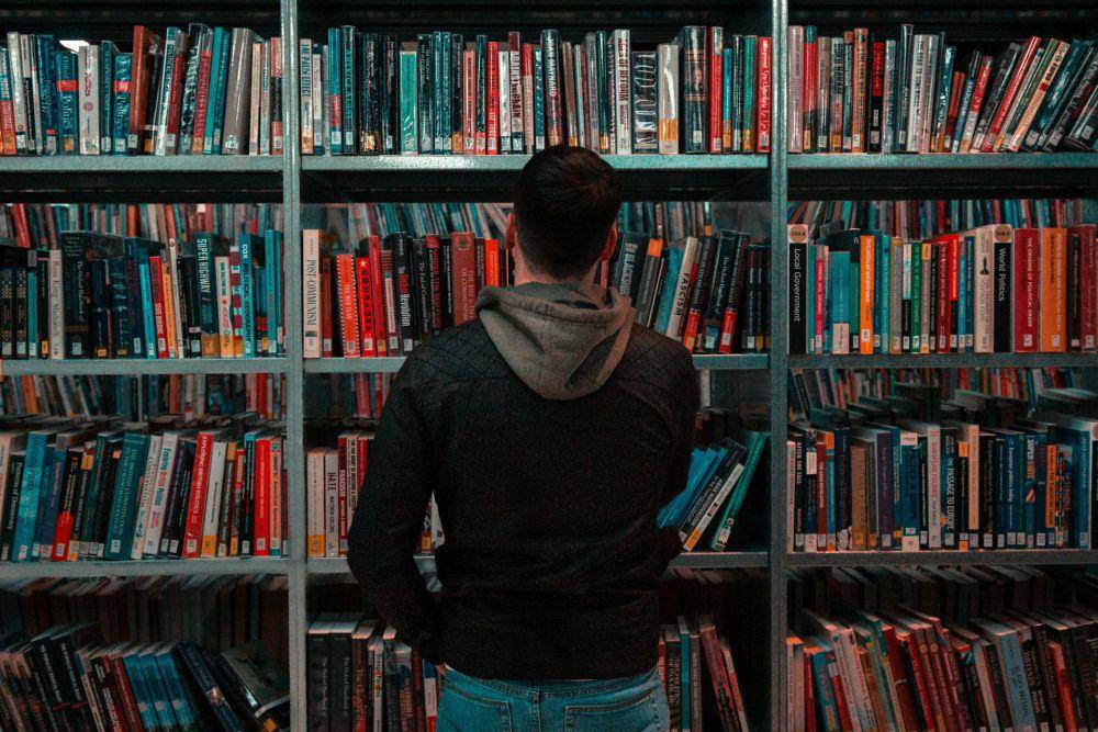 ilustrasi seorang pria di perpustakaan (unsplash.com/matthew Feeney)