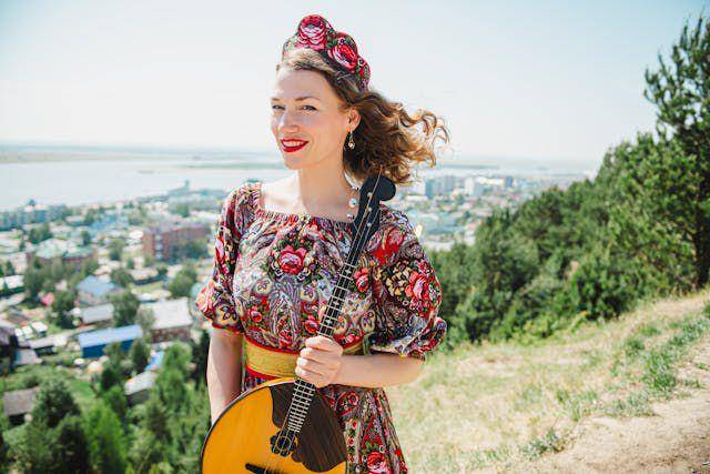 Seorang perempuan membawa Dombra, salah satu alat musik di Kazakhstan (pexels.com/Konstantin Mishchenko)