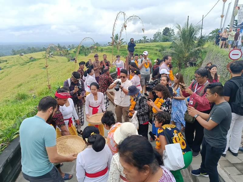 Para peserta field trip World Water Forum ke-10 menampi beras di Desa Wisata Jatiluwih bersama ibu-ibu warga sekitar, Sabtu (25/5/2024). (Dok. Kementerian PUPR)