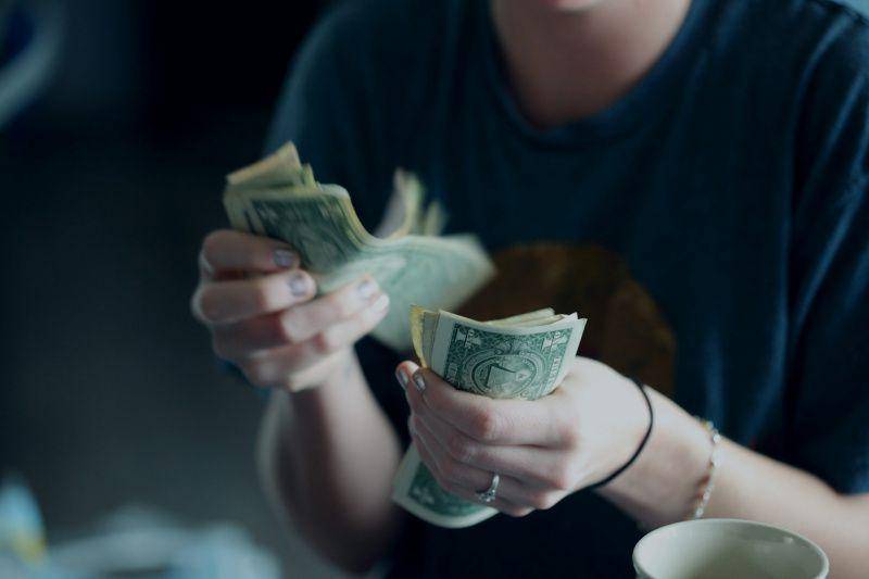 gambar orang sedang menghitung uang (unsplash.com/Alexander Grey)