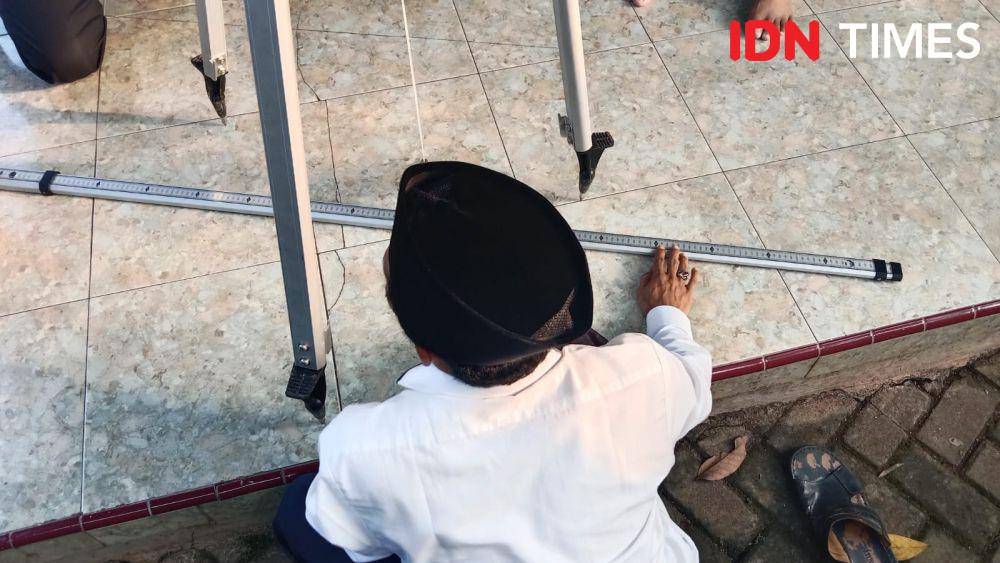 Seorang petugas saat mengukur arah kiblat menggunakan metode rasdhlul kiblat. (IDN Times/Fariz Fardianto)
