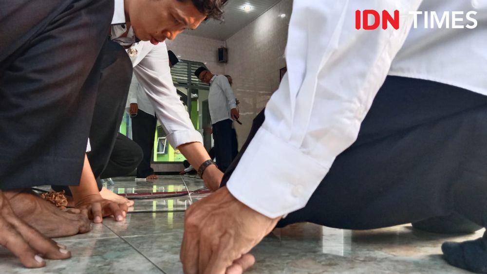 Dua petugas dengan teliti memperbaiki barisan saf untuk menyesuaikan arah kiblat yang baik dan benar. (IDN Times/Fariz Fardianto)