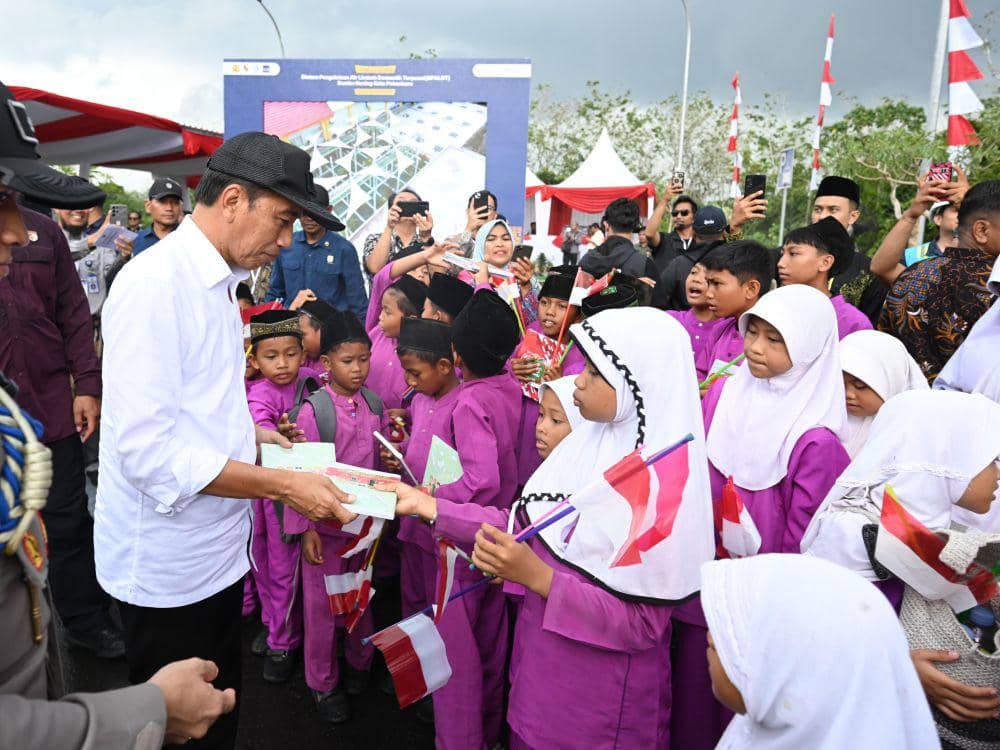 Jokowi saat membagikan buku kepada anak-anak sebelum berangkat ke Kota Dumai (IDN Times/ dok biro pers sekretariat presiden)