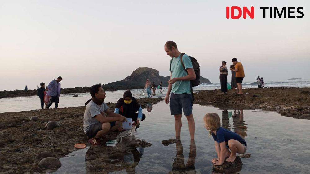 Turis asing ikut berburu nyale atau cacing laut di Pantai Seger Kuta Lombok Tengah. (IDN Times/Muhammad Nasir)