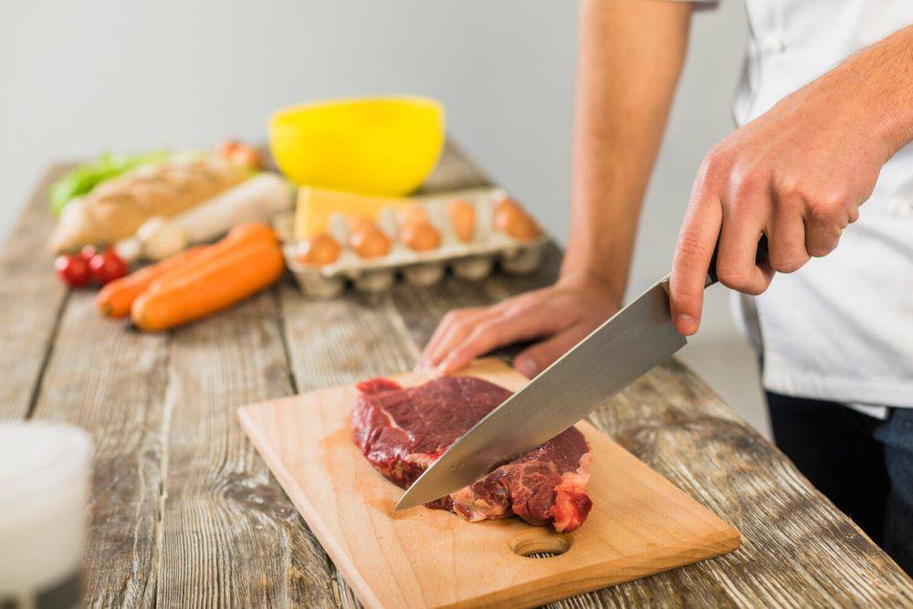 ilustrasi seseorang memotong daging (freepik.com/freepik)