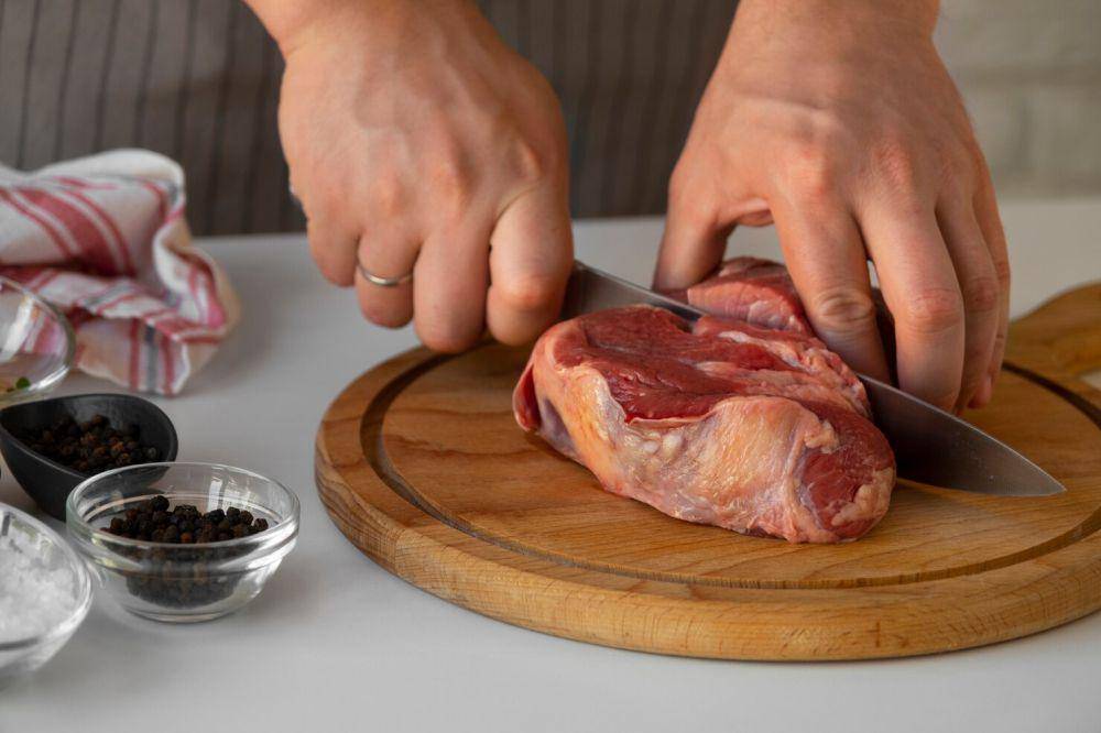 ilustrasi seseorang memotong daging (freepik.com/freepik)