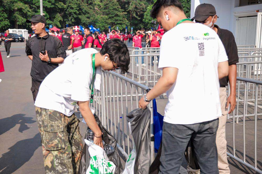 Pegadaian gelar kegiatan bersih-bersih di Stadion Gelora Bung Karno Jakarta setelah pertandingan Indonesia vs Irak, pada Kamis lalu (06/06). Kegiatan ini merupakan bentuk komitmen Pegadaian dalam penerapan Tujuan Pembangunan Berkelanjutan nomor 11, yaitu kota dan permukiman yang berkelanjutan. (Dok. Pegadaian)