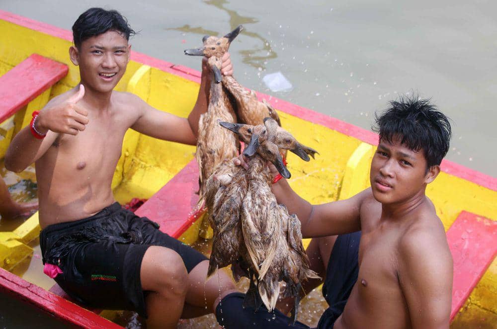 Warga menunjukkan bebek hasil tangkapannya usai mengikuti tradisi lomba tangkap bebek di Sungai Cisadane, Kota Tangerang, Banten, Senin (10/6/2024). (ANTARA FOTO/Muhammad Iqbal)