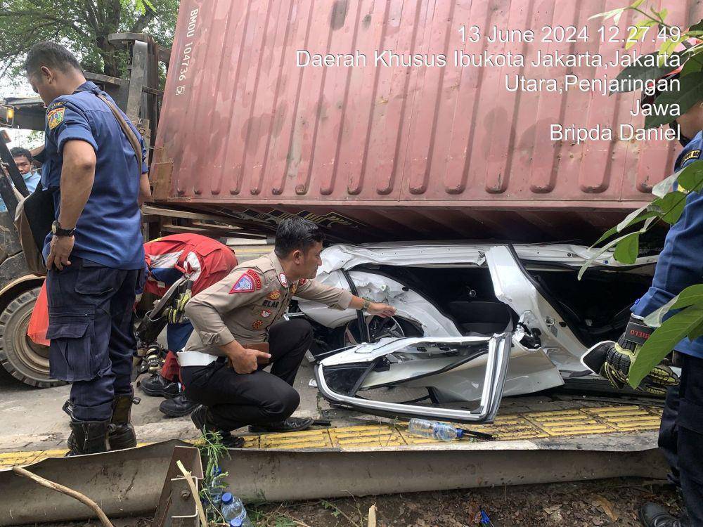 Sebuah truk kontainer terguling dan menimpa mobil Hyundai dengan nomor polisi B 2192 UYG di Jalan Kamal Muara Raya, Jakarta Utara, Kamis (13/6/2024) pukul 11.00 WIB. (Dok. Istimewa)