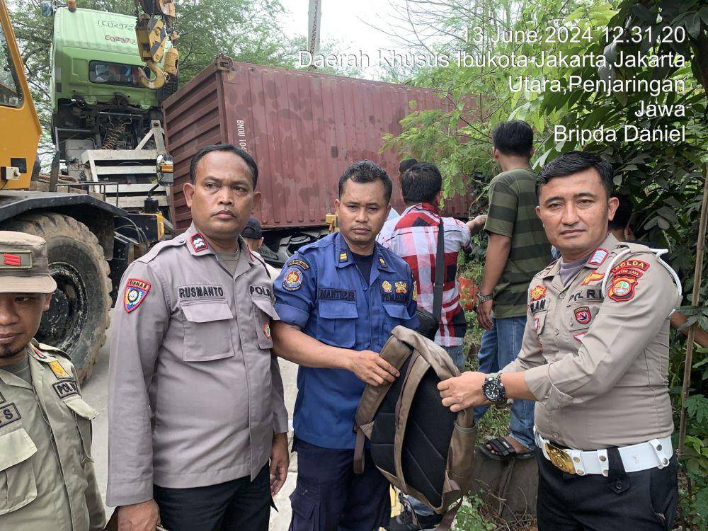 Sebuah truk kontainer terguling dan menimpa mobil Hyundai dengan nomor polisi B 2192 UYG di Jalan Kamal Muara Raya, Jakarta Utara, Kamis (13/6/2024) pukul 11.00 WIB. (Dok. Istimewa)