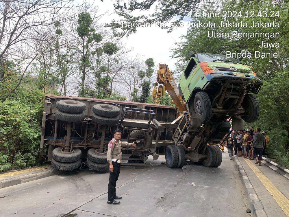 Sebuah truk kontainer terguling dan menimpa mobil Hyundai dengan nomor polisi B 2192 UYG di Jalan Kamal Muara Raya, Jakarta Utara, Kamis (13/6/2024) pukul 11.00 WIB. (Dok. Istimewa)