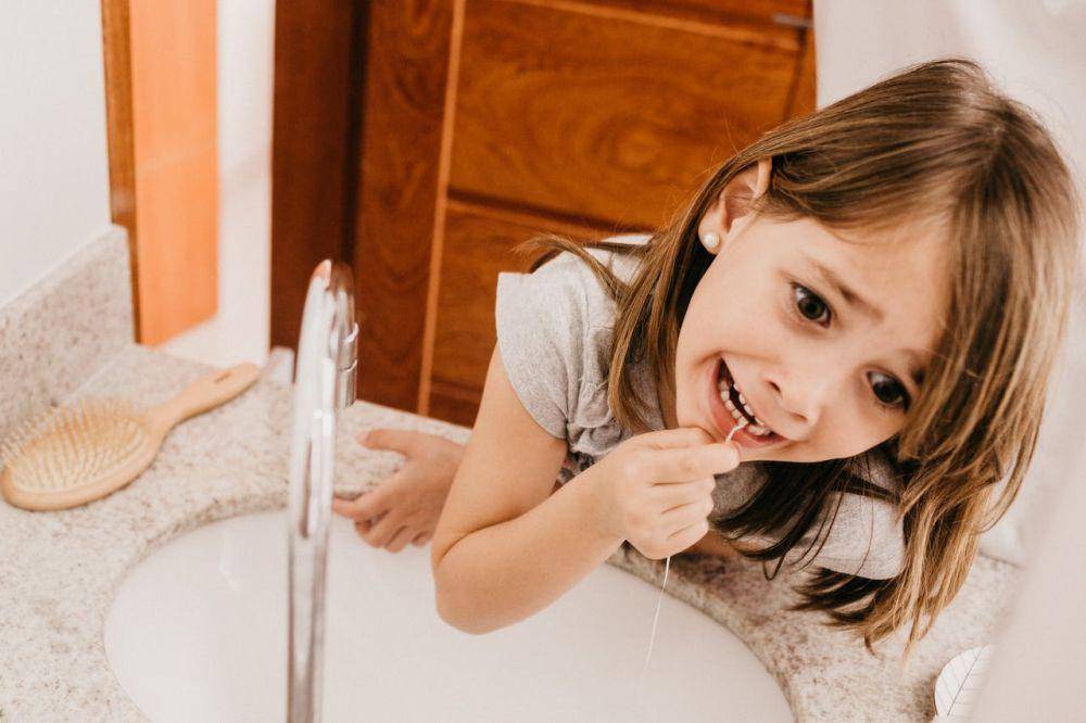 ilustrasi anak membersihkan gigi dengan benang gigi atau flossing (pexels.com/Jonathan Borba)
