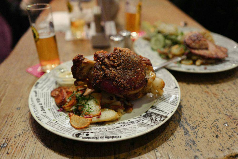 schweinshaxe yang menjulang di atas piring (unsplash.com/sofia lyu)