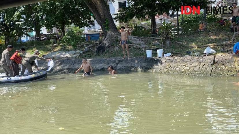 Tim dari DLH dan Satpol PP Kota Surabaya saat menemukan masyarakat membuang limbah rumen di Sungai, Senin (17/6/2024). (IDN Times/Khusnul Hasana).