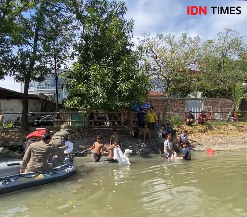 Tim dari DLH dan Satpol PP Kota Surabaya saat menemukan masyarakat membuang limbah rumen di Sungai, Senin (17/6/2024). (IDN Times/Khusnul Hasana).