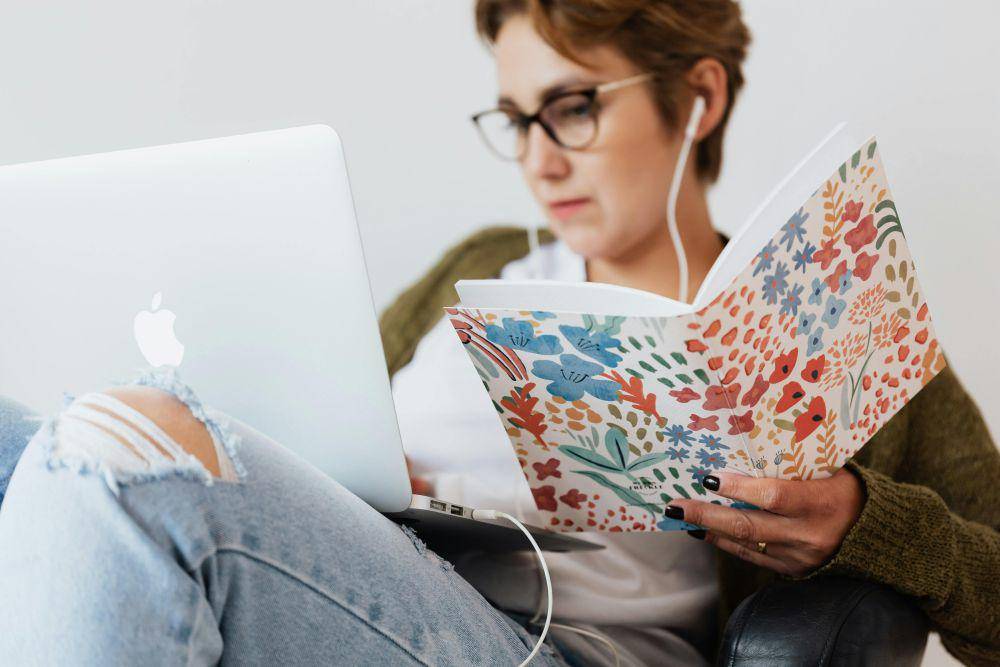 ilustrasi orang terdistraksi laptop ketika sedang membaca (pexels.com/Karoline Kaboompics)