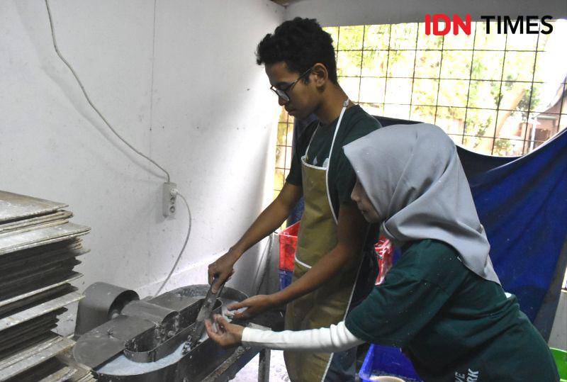 Salah satu siswa SLB Cicendo, Fatih, dibantu Asti, tengah membuat bubur dari limbah kertas, Rabu (26/6/2024). IDN Times/Debbie Sutrisno
