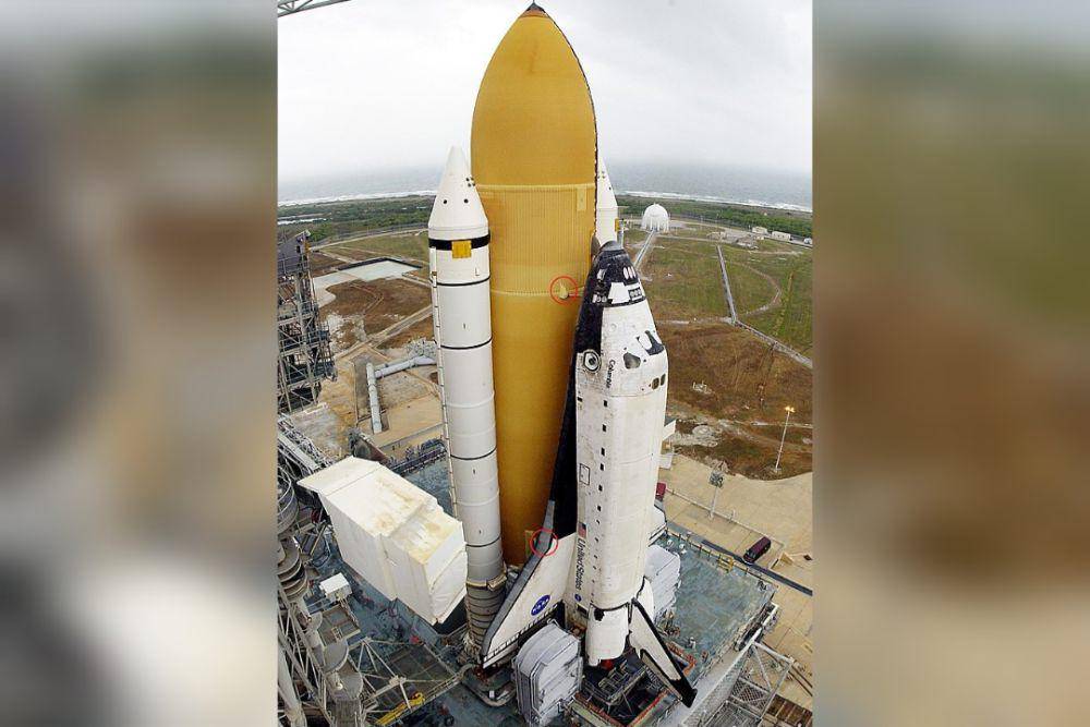 Pesawat Ulang-alik Columbia di Kompleks Peluncuran Kennedy Space Center 39A, menunjukkan lingkaran merah bagian atas yang merupakan busa yang jatuh saat peluncuran dan lingkaran merah bawah yang merupakan lokasi yang rusak akibat busa tersebut. (commons.wikimedia.org/NASA)